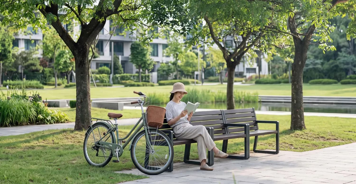 Người phụ nữ đọc sách trên ghế nghỉ cạnh chiếc xe đạp